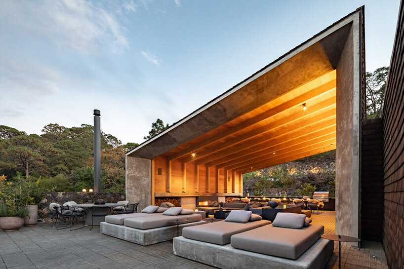 nestled atop steep hills, these twin houses in mexico weave into their forested context