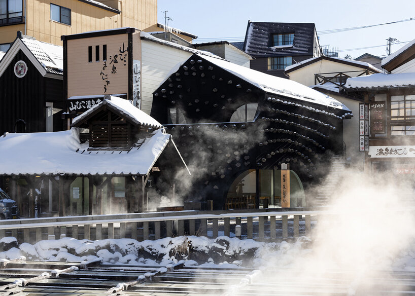 kengo kuma adds local stone to hot spring inn in kusatsu, japan