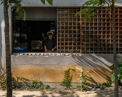 overlapping social areas and lush gardens emerge from renovated warehouse in thailand