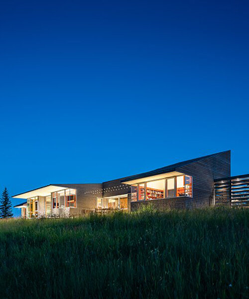 stillwater residence emerges as a series of farm sheds within verdant veil of montana