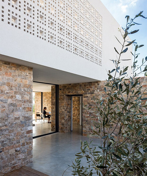 stone volumetry and checkered perforations articulate this minimalist house in israel