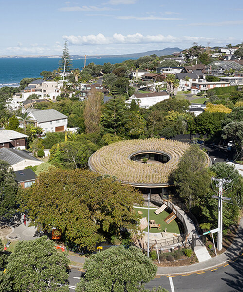 smith architects tops learning center in new zealand with circular green roof canopy