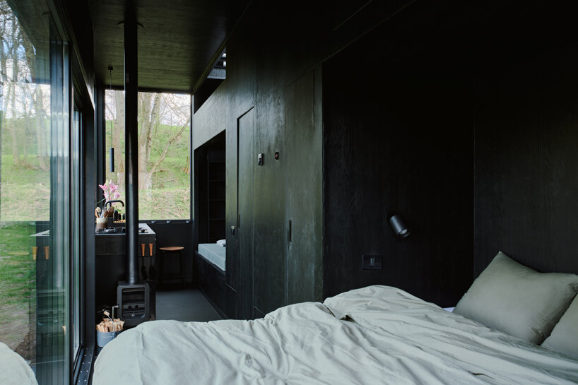 sigurd larsen makes nature the protagonist of a calm black cabin hideaway
