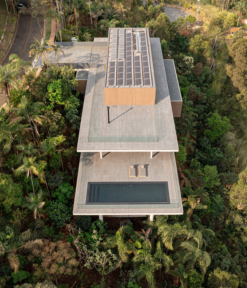 'minas house' by studio MK27 is a stilted concrete volume set amid a rainforest garden