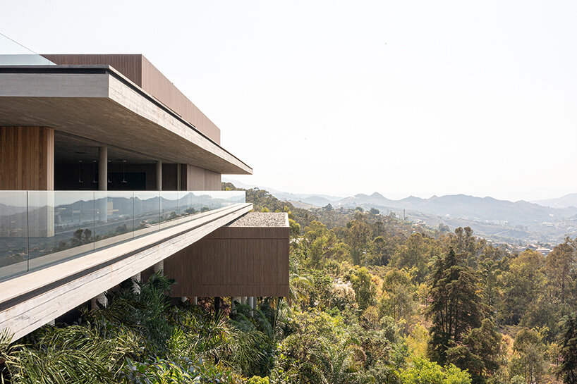 'minas house' by studio MK27 is a stilted concrete volume set amid a rainforest garden