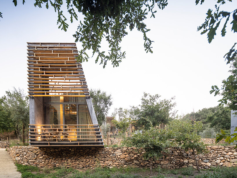 summary architecture scatters tiny hotel cabins over idyllic landscape of paradinha