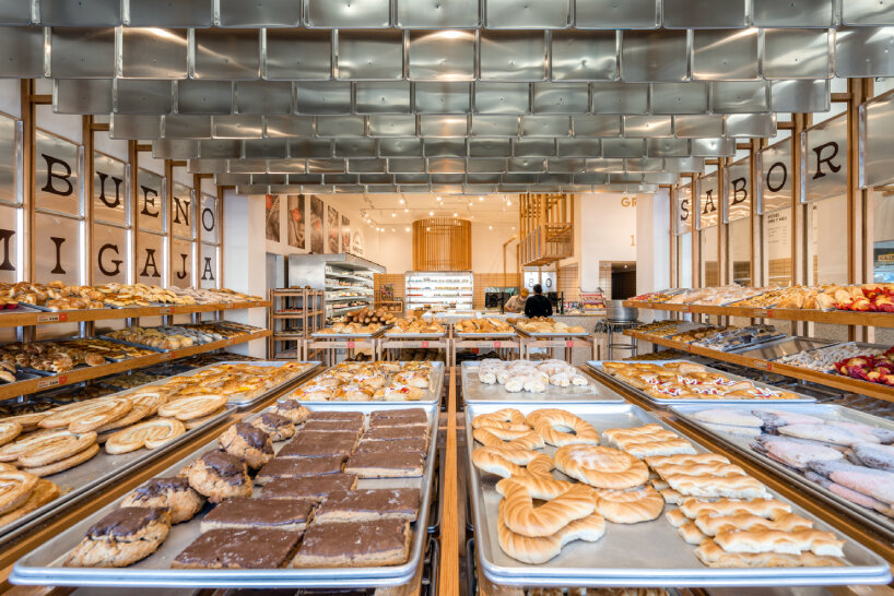 concèntrico envelops mi pan bakery with hanging metallic trays and pinewood in mexico