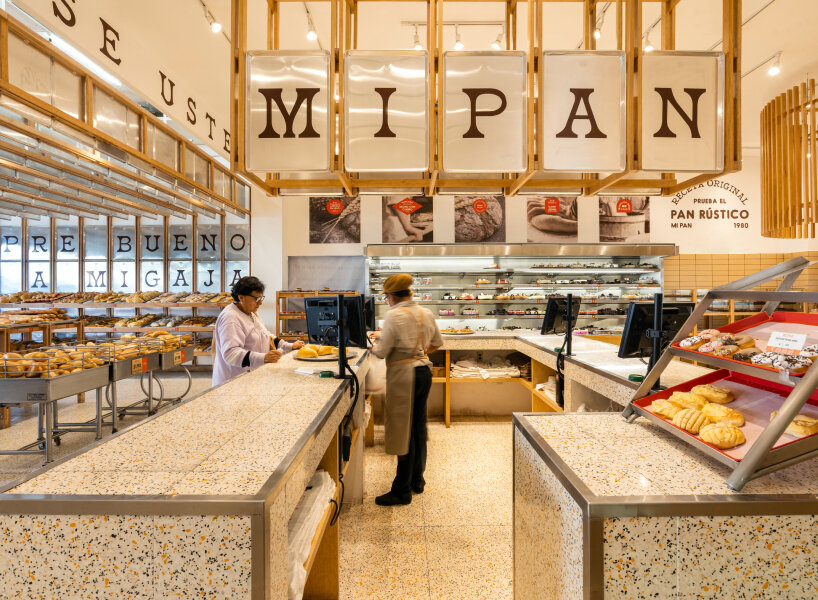 concèntrico envelops mi pan bakery with hanging metallic trays and pinewood in mexico