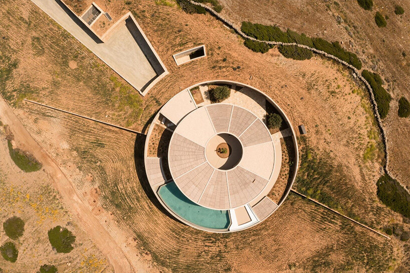DECA's 'cronus' circular villa nestles into arid island landscape in greece