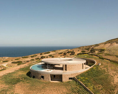 DECA's 'cronus' circular villa nestles into the arid island landscape in greece