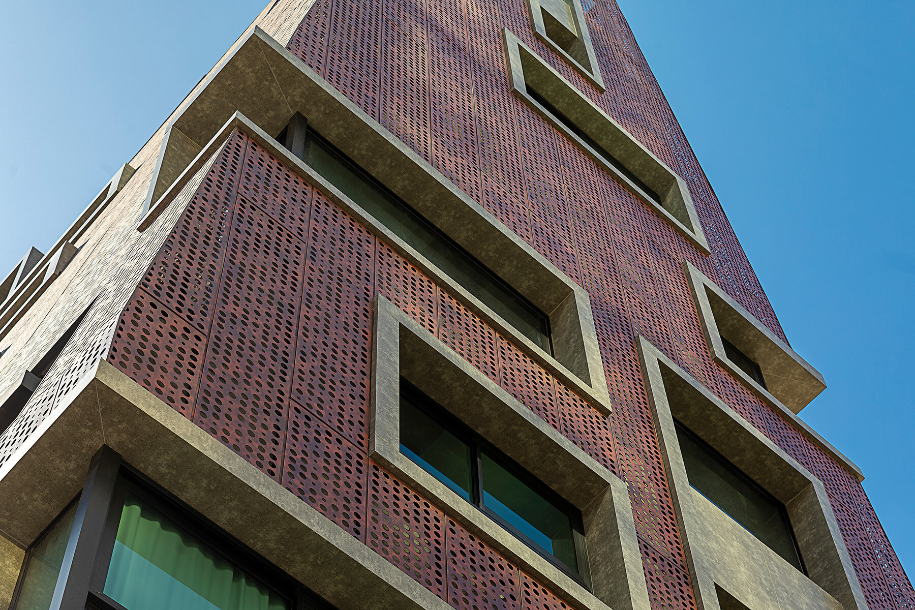 perforated-red-alminum-skin-envelops-gisele-borges-pyramidal-residential-building-in-brazil-designboom-full-width-02