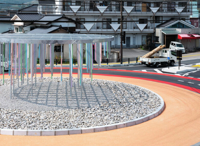 Roundabout installation by takao shiotsuka workshop drips like paint through colored steel pipes