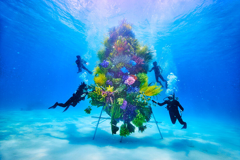 azuma makoto submerges intricate botanical sculpture in the clear waters of japan