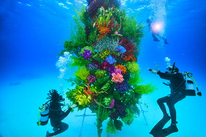 azuma makoto submerges intricate botanical sculpture in the clear waters of japan