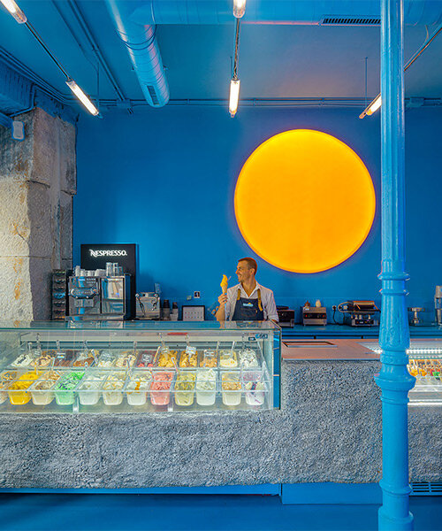 luminous 'sun' lamp brightens all-blue ice cream shop interior in madrid, spain