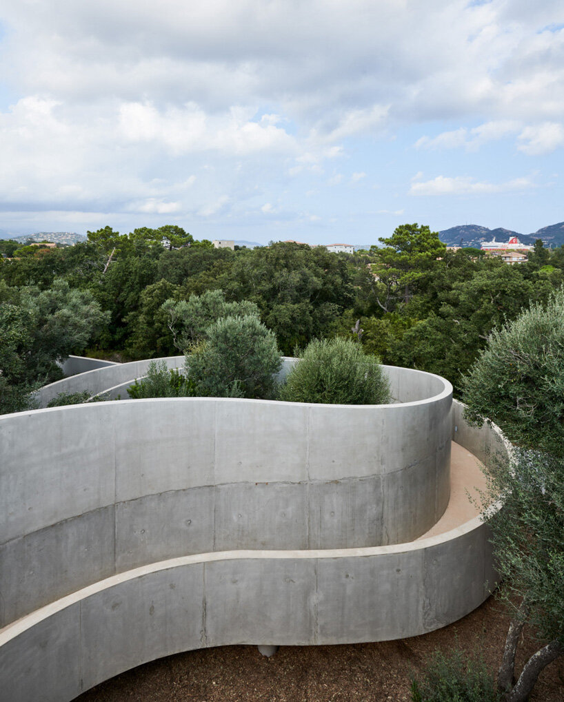 dominique coulon animu media library's concrete curves embrace the site's existing landscape in porto-vecchio