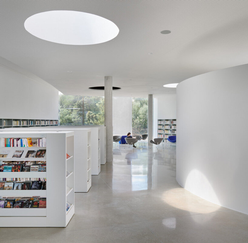 the concrete curves of the animu media library embrace the existing landscape of the porto-vecchio site
