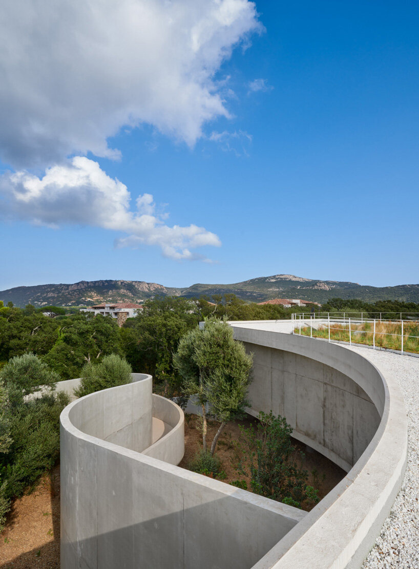 dominique coulon animu media library's concrete curves embrace the site's existing landscape in porto-vecchio