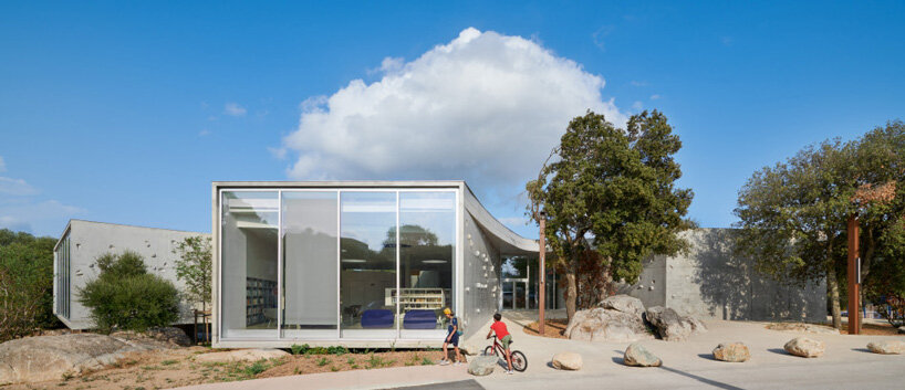 dominique coulon animu media library's concrete curves embrace the site's existing landscape in porto-vecchio