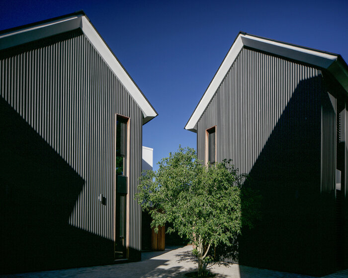 nestled in a cross-shaped plan, these duplex houses in uruguay boast striking visual rhythms