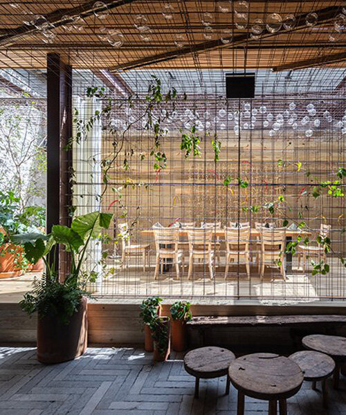 rustic mexican restaurant engulfs diners with metallic mesh net woven with lush greenery