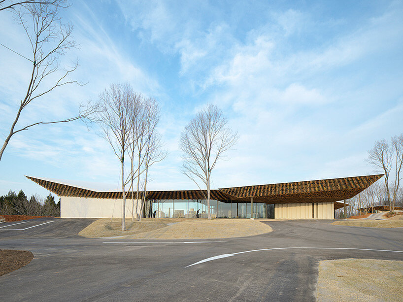 kengo kuma's firewood roof for 'snow peak' spa resort echoes mountain ridgeline in japan