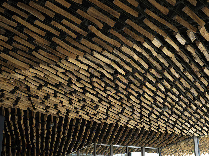kengo kuma's firewood roof for 'snow peak' spa resort echoes mountain ridgeline in japan