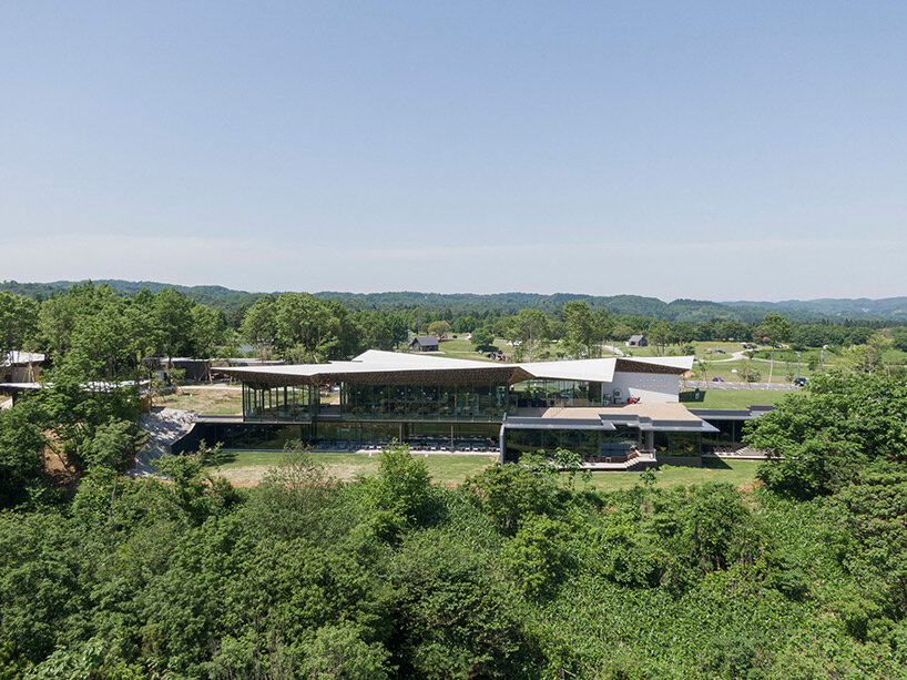 kengo kuma's firewood roof for 'snow peak' spa resort echoes mountain ridgeline in japan