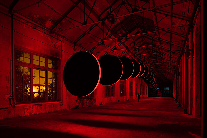 20 large discs move hypnotically against a red-lit backdrop in SpY's latest kinetic artwork