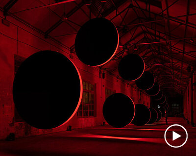 20 large discs move hypnotically against a red-lit backdrop in SpY's latest kinetic artwork