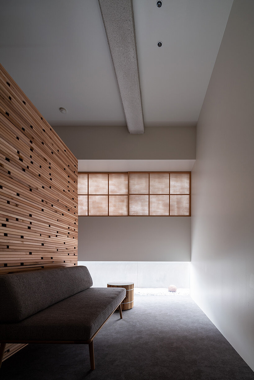 fronted with a porous wooden facade, the 'takayama hotel' in japan evokes a forestscape