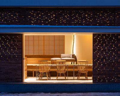 fronted with a porous wooden facade, the 'takayama hotel' in japan evokes a forestscape