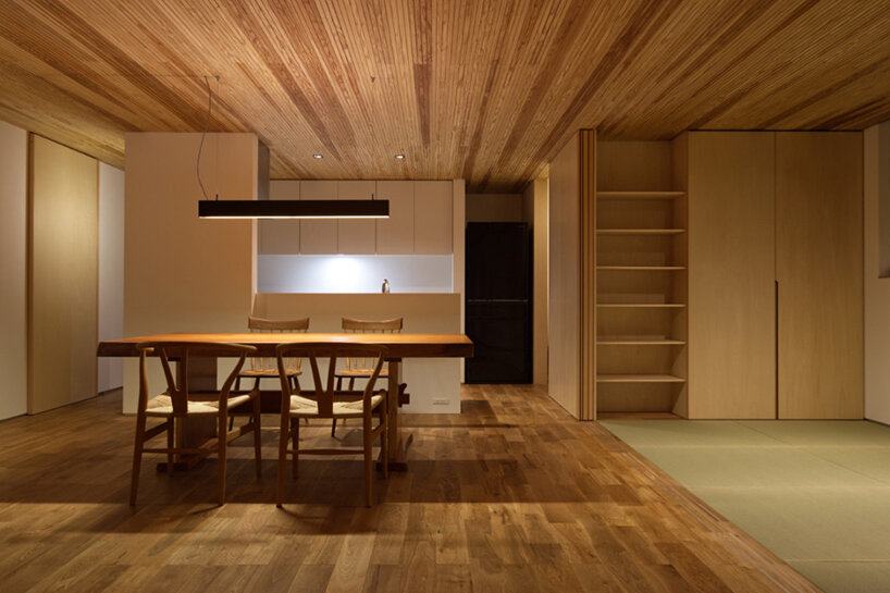 'house in tensui' emerges as a multi-layered wooden volume amid terraced fields in japan