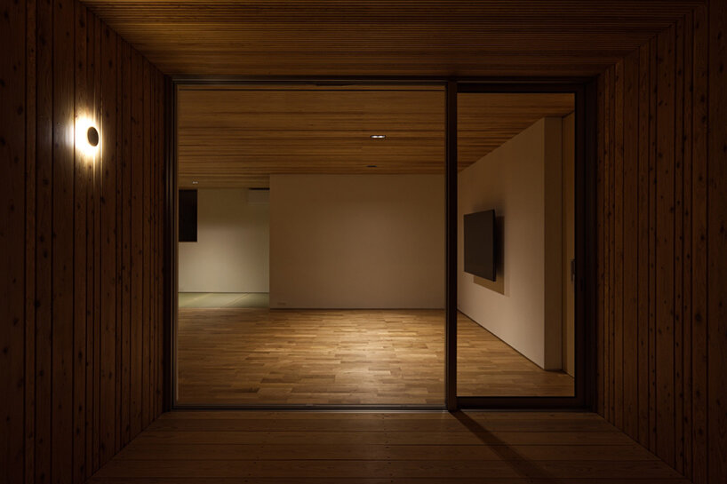 'house in tensui' emerges as a multi-layered wooden volume amid terraced fields in japan