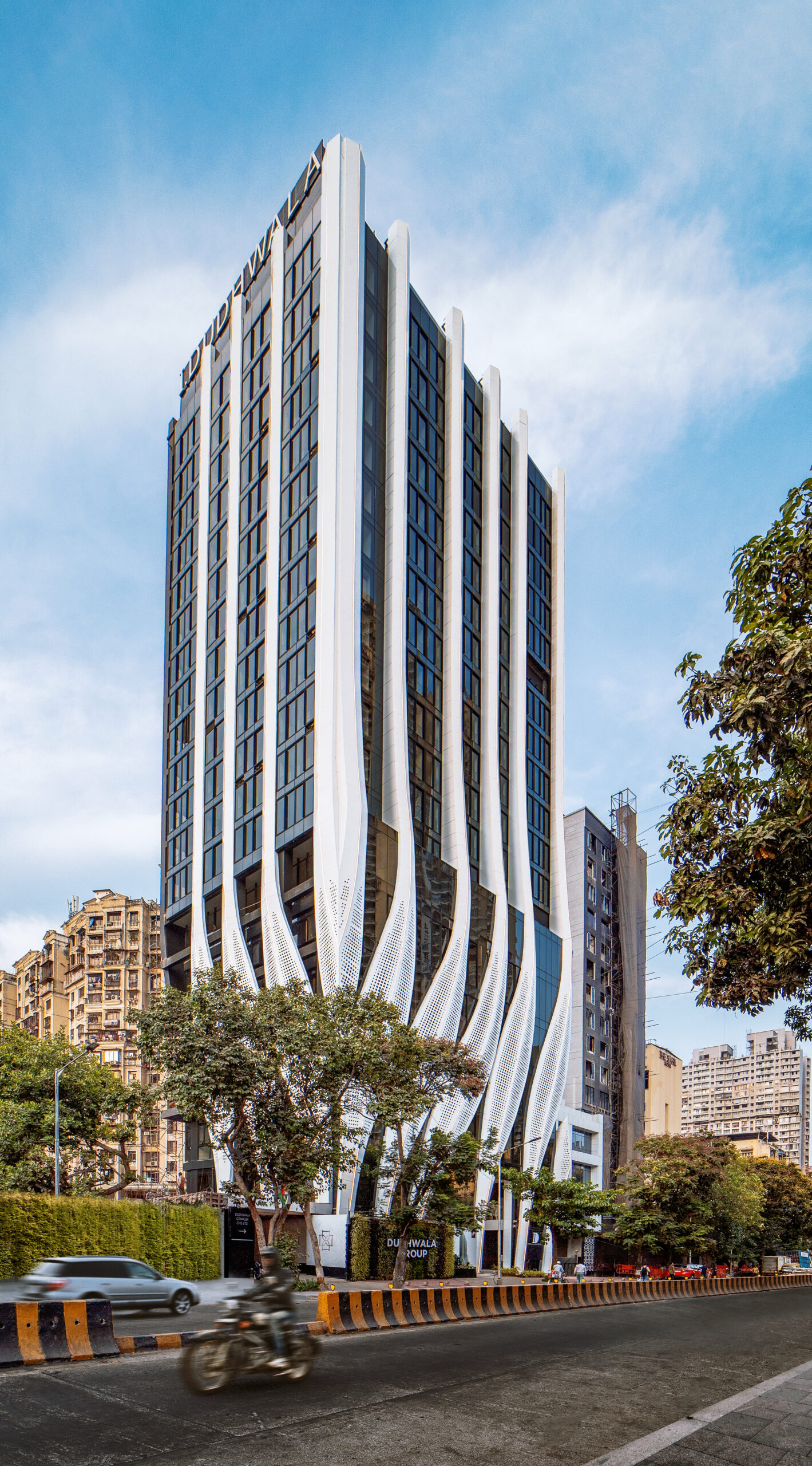 perforated calligraphic panels clad mix-use tower by studio symbiosis emerging from mumbai’s cityscape