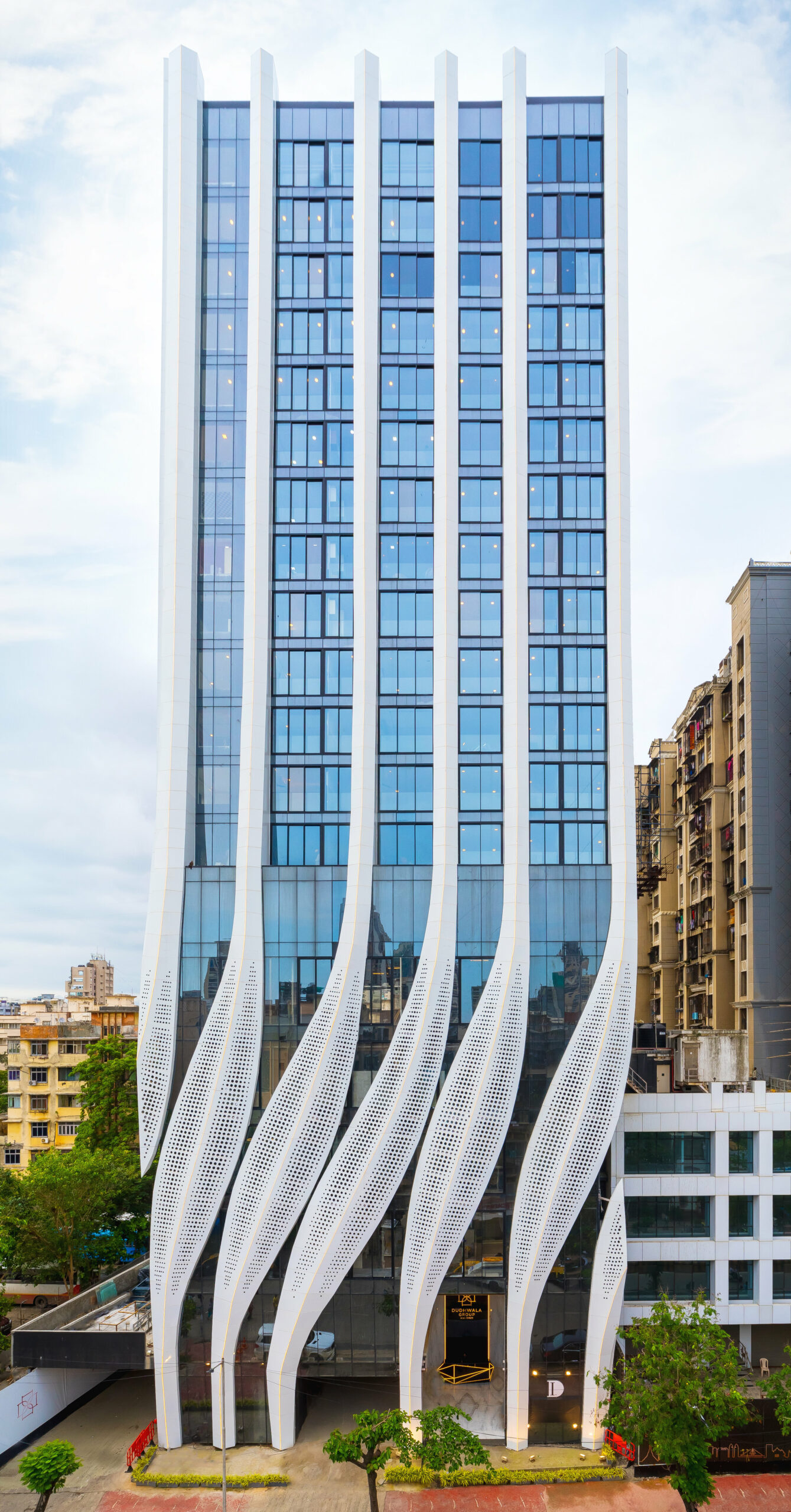 perforated calligraphic panels clad mix-use tower by studio symbiosis emerging from mumbai’s cityscape