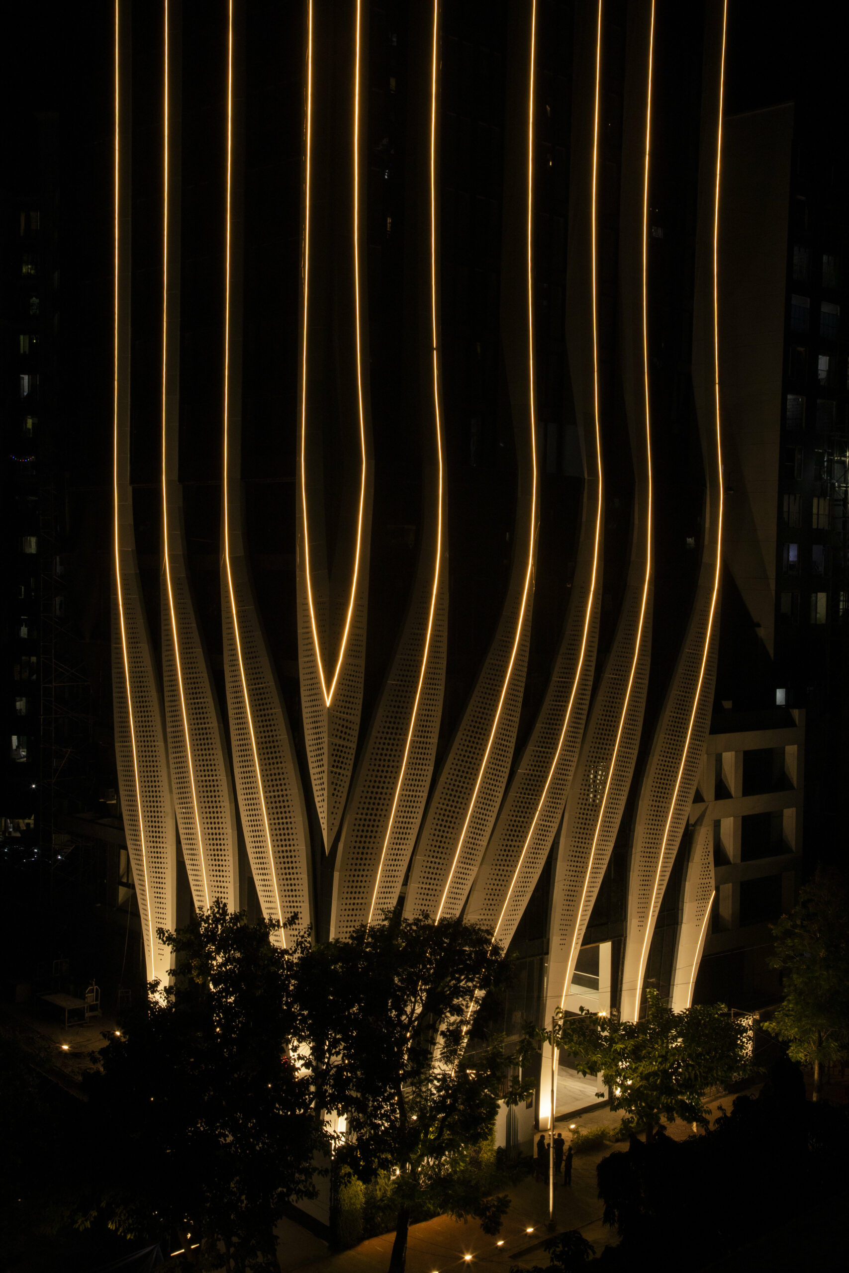 perforated calligraphic panels clad mix-use tower by studio symbiosis emerging from mumbai’s cityscape