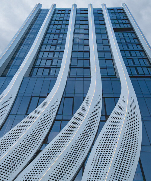 perforated calligraphic panels clad mix-use tower emerging from mumbai’s cityscape