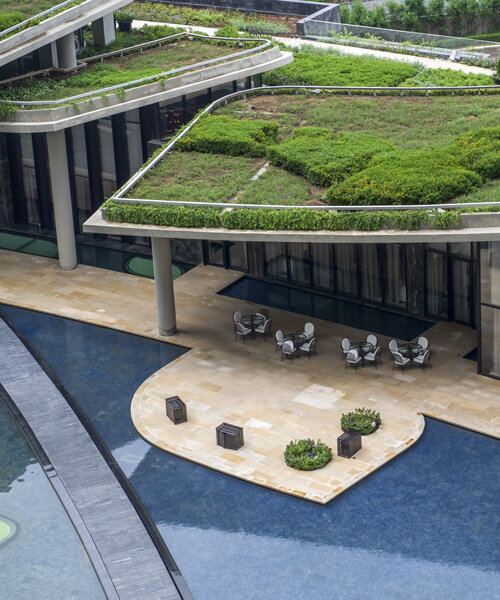 overlapping green roofs enclose this 'camellias' wellness club in india