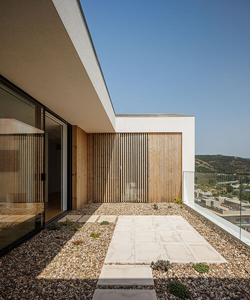 a minimalist house by mário alves emerges from the hills over coimbra, portugal
