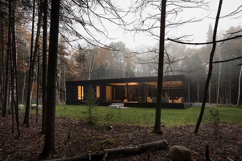 in quebec forests, a glass home surrounds an apple tree courtyard