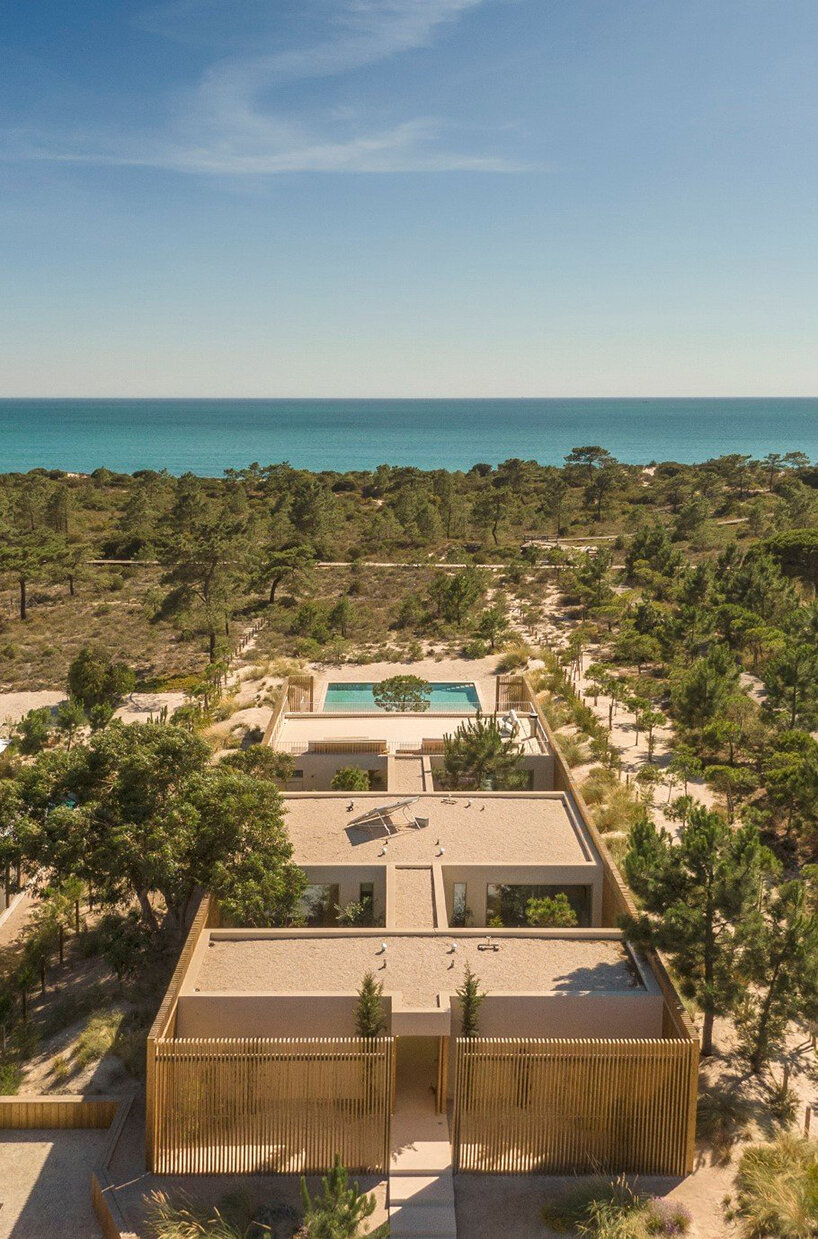 in portugal, 'casa em tróia' by BICA arquitectos seamlessly mirrors its coastal surroundings