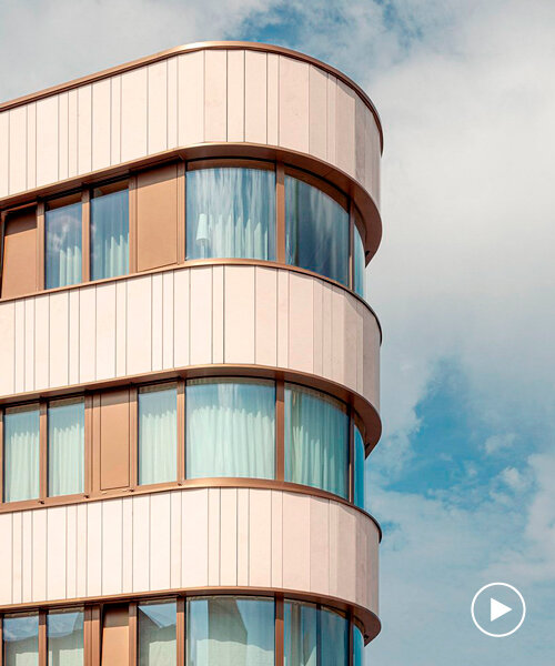limestone and glass wrap around the curved facade of residential building in luxembourg