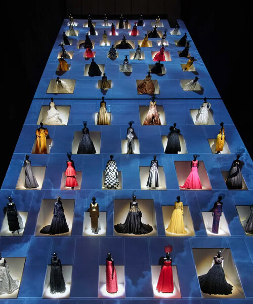 mannequins in gowns climb up a giant slope in OMA-designed dior exhibition in tokyo
