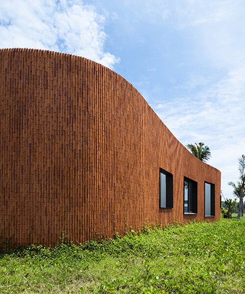 a vivid brick shell envelops inrestudio's bean-shaped laboratory in vietnam