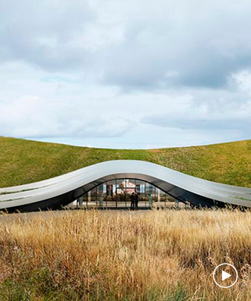 unism studio blends subterranean factory's green roof into the polish rural landscape
