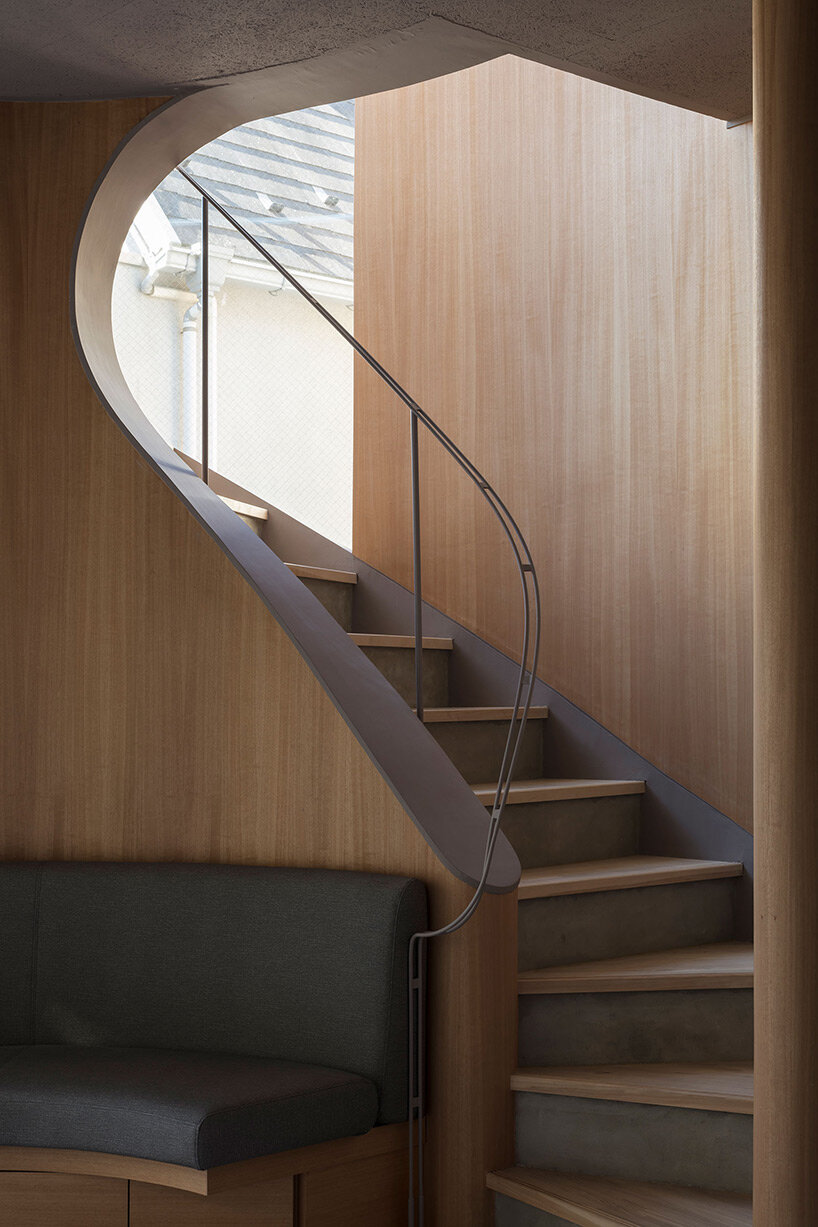 curved glass-enclosed staircase peeps out of tokyo house that 'dances in the city'