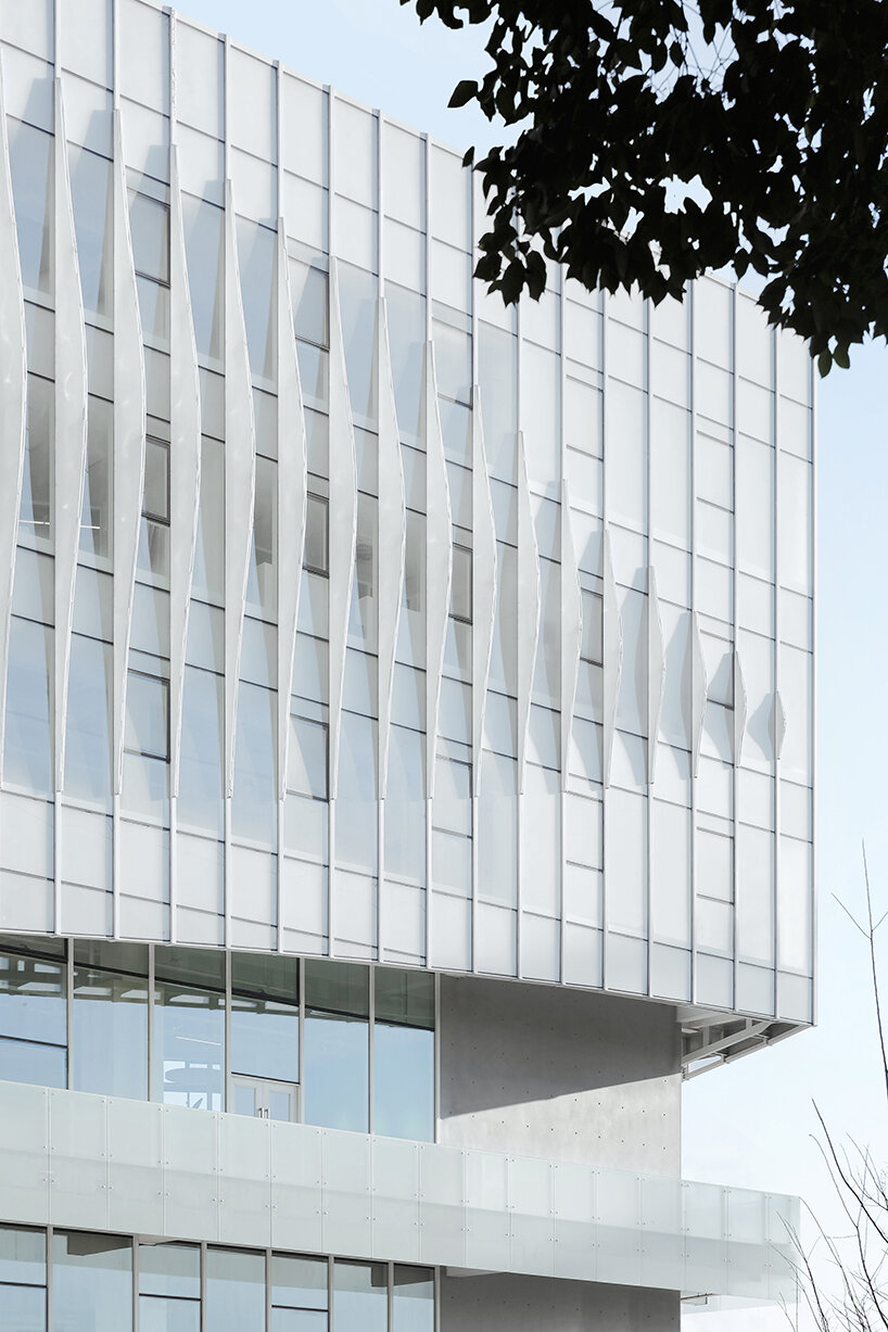 feather-shaped reliefs adorn this mixed-use building façade in eastern china