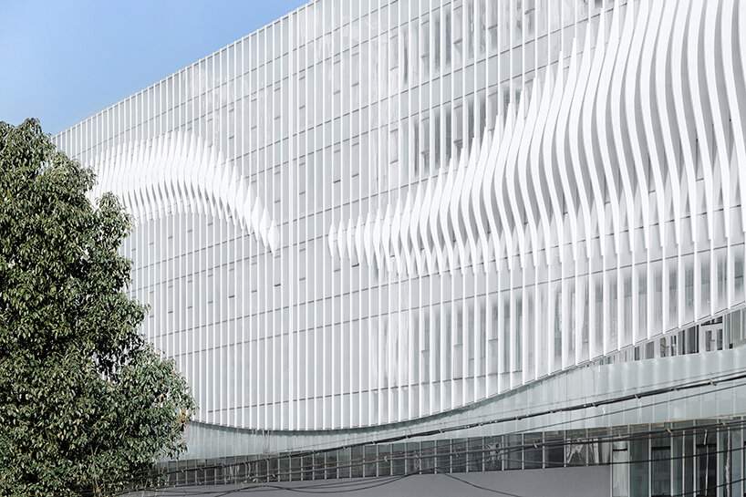 feather-shaped reliefs adorn this mixed-use building façade in eastern china