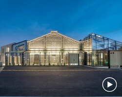 historic latvian cargo warehouse revived as cultural center, encased in glass and steel shell